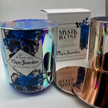 Load image into Gallery viewer, Full of floral notes and tones the fragrance of roses blossoming note the beginning of Spring and carry into Summer. Intense incense adds depth to this candles burn and will create a serene mood in any space. Blue Mystk Rose designed by Cape Jasmine Wax Co is available in a metallic Rose Gold and Iridescent Glass Candle. Both come with Rose Gold lids.
